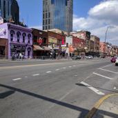 Street view showing several bars where live bands play in downtown Nashville during the day.